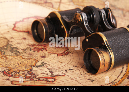 Old binoculars on antique map. Shallow depth of field Stock Photo