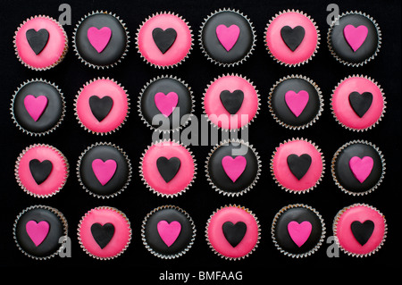 Mini cupcakes decorated with black and pink icing and heart shapes Stock Photo