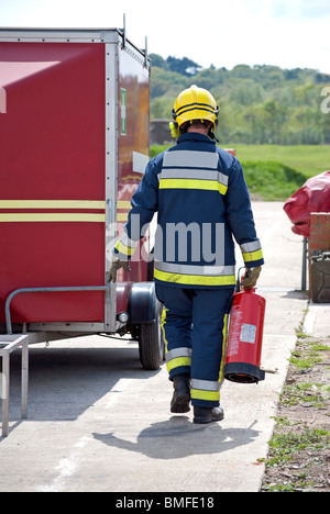 Fireman carrying an extinguisher Stock Photo