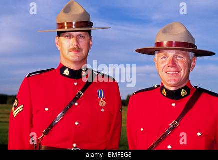 Two smiling Royal Canadian Mounted Police in their traditional bright Red Serge dress uniform jackets in New Brunswick, Canada. Stock Photo