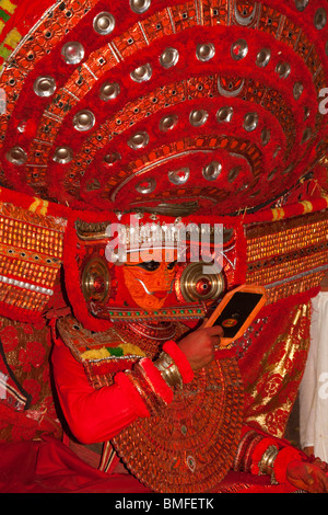 India, Kerala, Cannanore (Kannur), Theyyam, Naga Kanni looking in mirror to become the serpent deity under trance Stock Photo