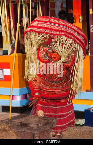 India, Kerala, Cannanore (Kannur), Theyyam, serpent deity Naga Kanni ritually breaking coconut on sacred stool Stock Photo