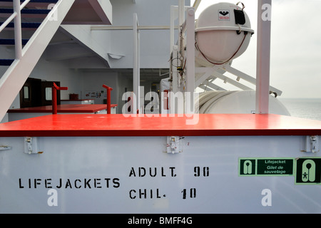 Box with life jackets / vests and inflatable liferafts in hard-shelled canisters on board of ferryboat, Europe Stock Photo