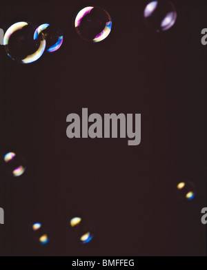 Assorted soap bubbles floating against black background Stock Photo