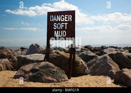 danger sign warning of soft mud at beach in UK Stock Photo