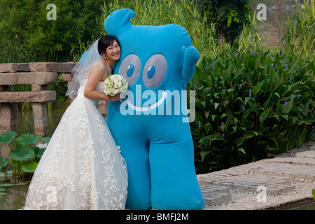 Bride take photos with the Shanghai 2010 World Expo mascot Haibao, Lotus Base, Jiading District, Shanghai, China Stock Photo