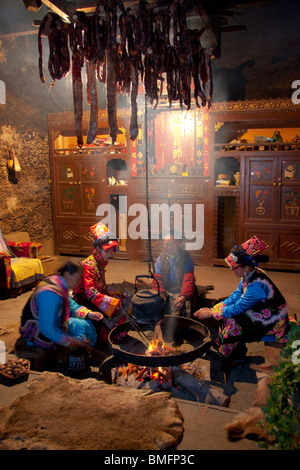 Qiang people sitting around a stove in the living room, Yingxiu, Wenchuan, Sichuan Province, China Stock Photo