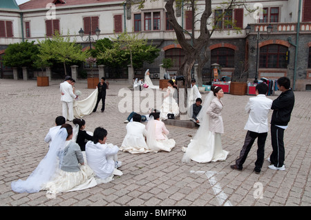 Chinese couples prepare to pose for wedding photos, Qingdao, China Stock Photo