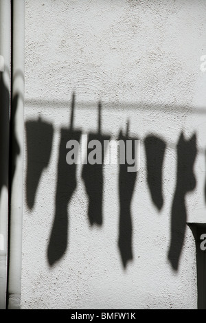 shadow of socks hanging on washing line in sun Stock Photo