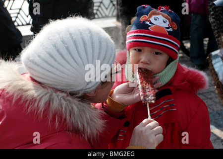 A child tasting traditional snack Tanghulu, Jilin, Jilin Province, China Stock Photo