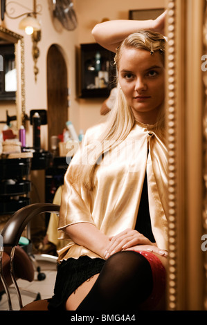 Woman looking in mirror at the hair salon Stock Photo
