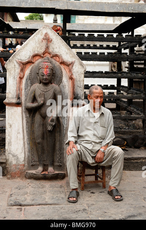 nepalese man  resting , sitting by the butterlamp pavilion,swayambhunath buddhist temple , kathmandu , nepal Stock Photo