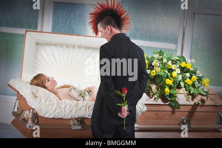 A Man Holding A Rose And Viewing A Deceased Woman Laying In A Coffin Stock Photo