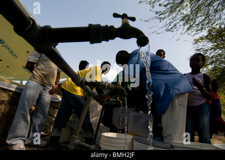 People filling buckets with drinking water in the street in Port au Prince after a 7.0 magnitude earthquake struck Haiti on 12 January 2010 Stock Photo