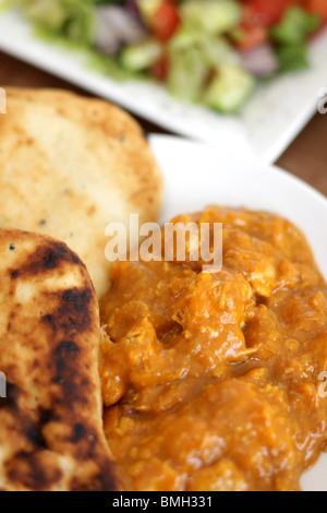 Freshly Made Indian Style Spicy Beef Madras Curry With Naan Bread And Fresh Salad With No People Stock Photo