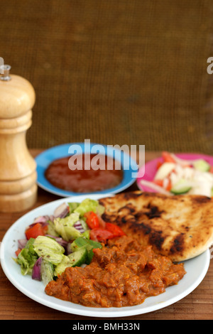 Freshly Made Indian Style Spicy Beef Madras Curry With Naan Bread And Fresh Salad With No People Stock Photo