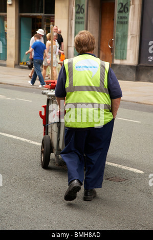 Street cleaner with slogan 'Be proud love Manchester' printed on the back of his vest Stock Photo