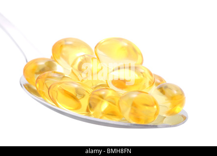 Fish oil capsules in spoon isolated on white Stock Photo