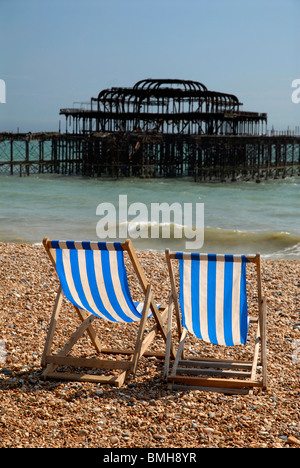 Deckchairs on the seafront at Brighton with the old pier destroyed by fire in the background, UK, 2010. Stock Photo