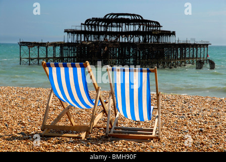 Deckchairs on the seafront at Brighton with the old pier destroyed by fire in the background, UK, 2010. Stock Photo