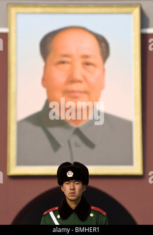 Guard standing under Chairman Maos Portrait outside The Forbidden City Beijing China Stock Photo