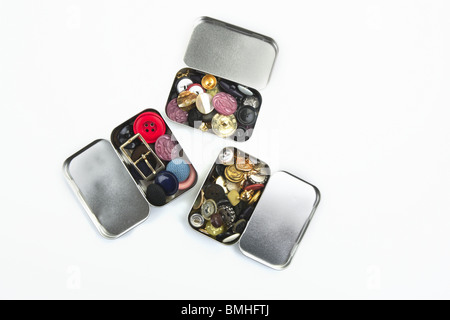 three clothing buttons metal boxes collection pattern Stock Photo