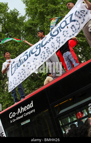 Demonstrators on a bus roof at the 'Freedom for Palestine' demonstration on Whitehall, Westminster, London, England, U.K. Stock Photo