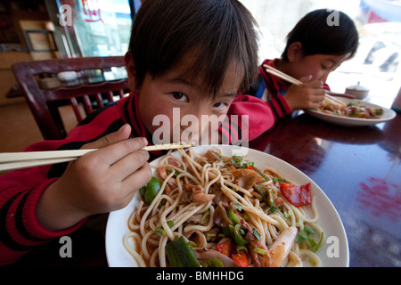 Brothers eating noodles in Shigatse, Tibet Stock Photo