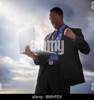 Successful businessman holding a laptop computer Stock Photo