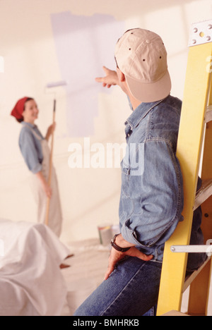 Couple painting the walls in their home Stock Photo