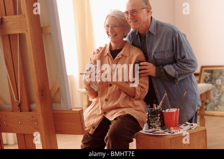 Couple admiring woman's painting Stock Photo