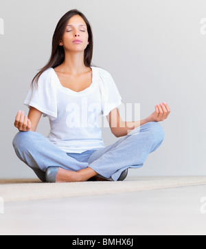 Woman sitting on floor meditating Stock Photo - Alamy
