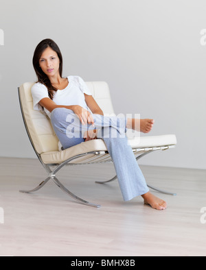 Relaxed woman sitting on modern chair Stock Photo