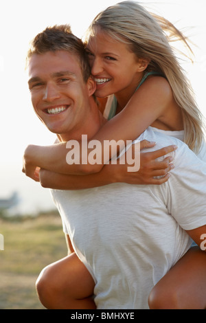 Handsome young man giving piggyback ride to his girlfriend. Couple