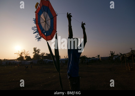 A boy flies a kite at a makeshift camp for survivors of a 7.0 magnitude earthquake which struck Haiti on 12 January 2010 in Port-au-Prince Stock Photo