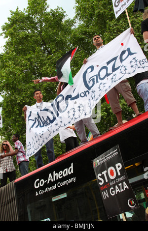 Demonstrators on a bus roof at the 'Freedom for Palestine' demonstration on Whitehall, Westminster, London, England, U.K. Stock Photo