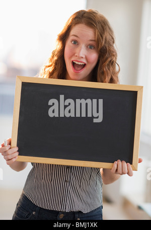 Woman holding a blank chalkboard Stock Photo