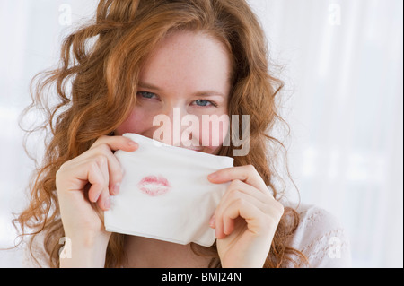 Woman holding tissue with lipstick on it Stock Photo