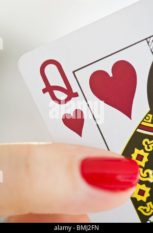 Hand holding a queen of hearts card Stock Photo