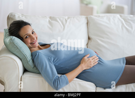 Pregnant woman resting on couch Stock Photo