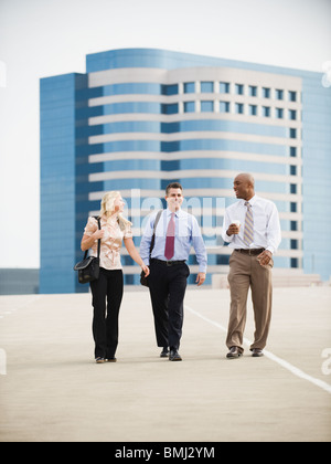 Co-workers walking in parking lot Stock Photo