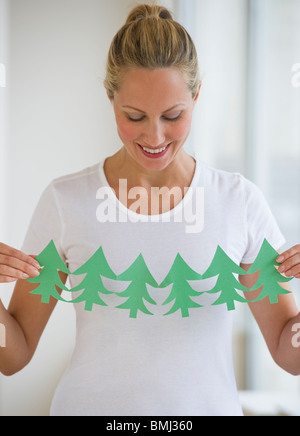Woman holding cut out of trees Stock Photo
