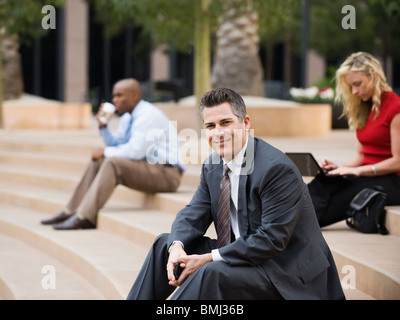 Business people sitting on outdoor steps Stock Photo