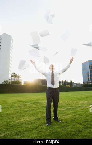 Businessman throwing papers in air Stock Photo