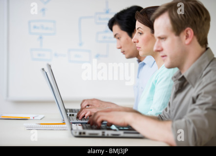 Adults working on laptops in classroom Stock Photo