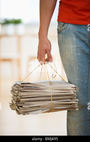 Man holding stack of newspapers Stock Photo