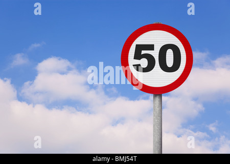 A round roadsign with the number 50 on it against a blue cloudy sky. Stock Photo