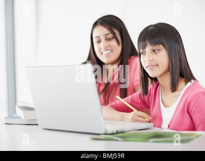 Students working on laptops in classroom Stock Photo