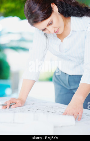 Woman looking at blueprints Stock Photo