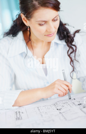 Woman looking at blueprints Stock Photo
